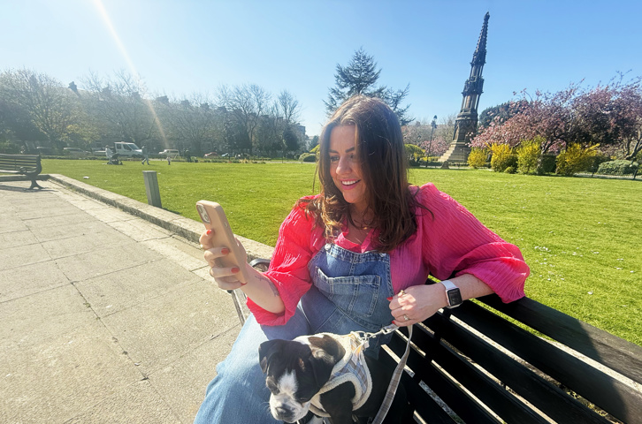 A woman on their phone smiling