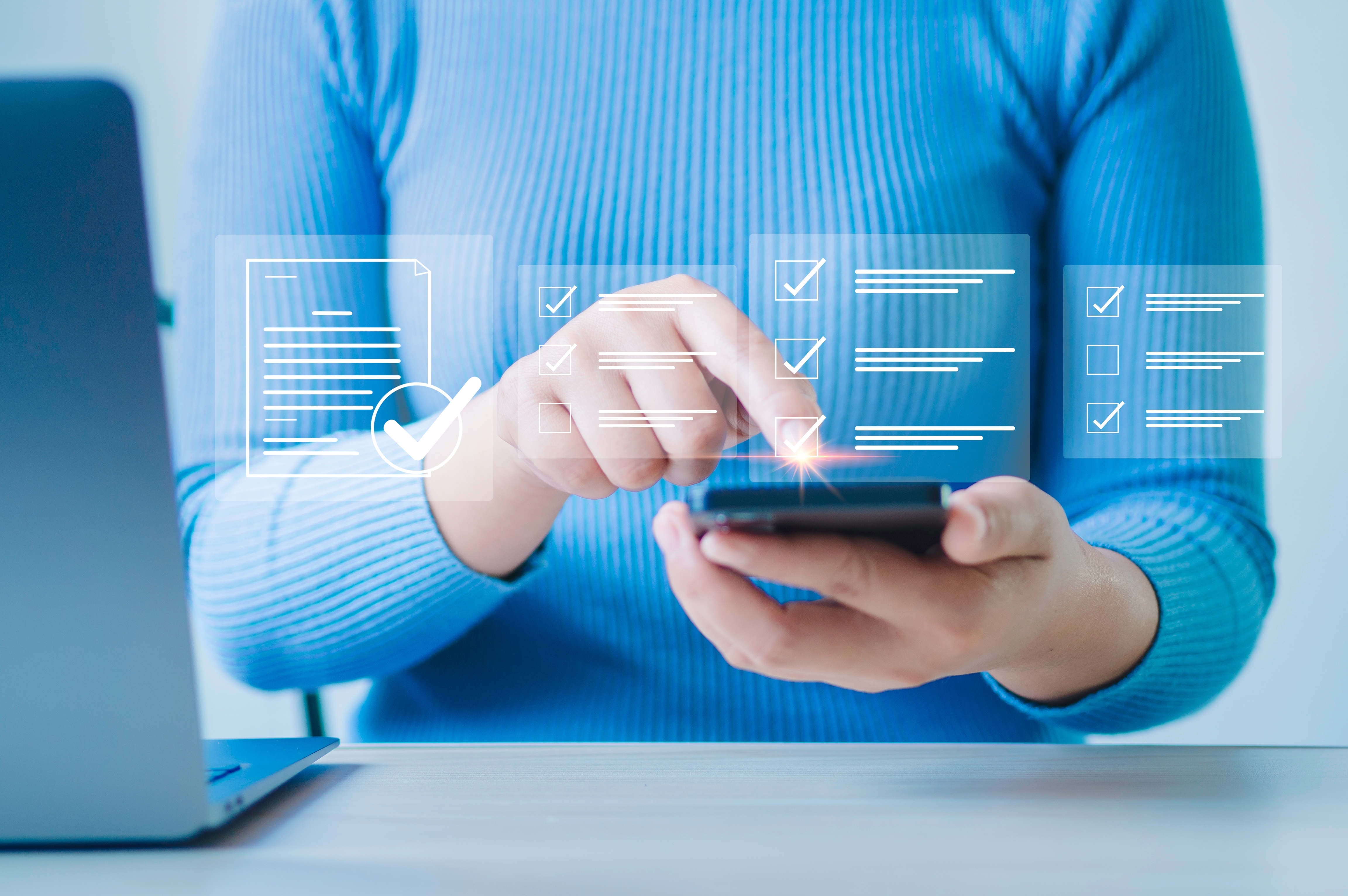Person tapping a smartphone with a digital checklist and tick boxes displayed on screen.