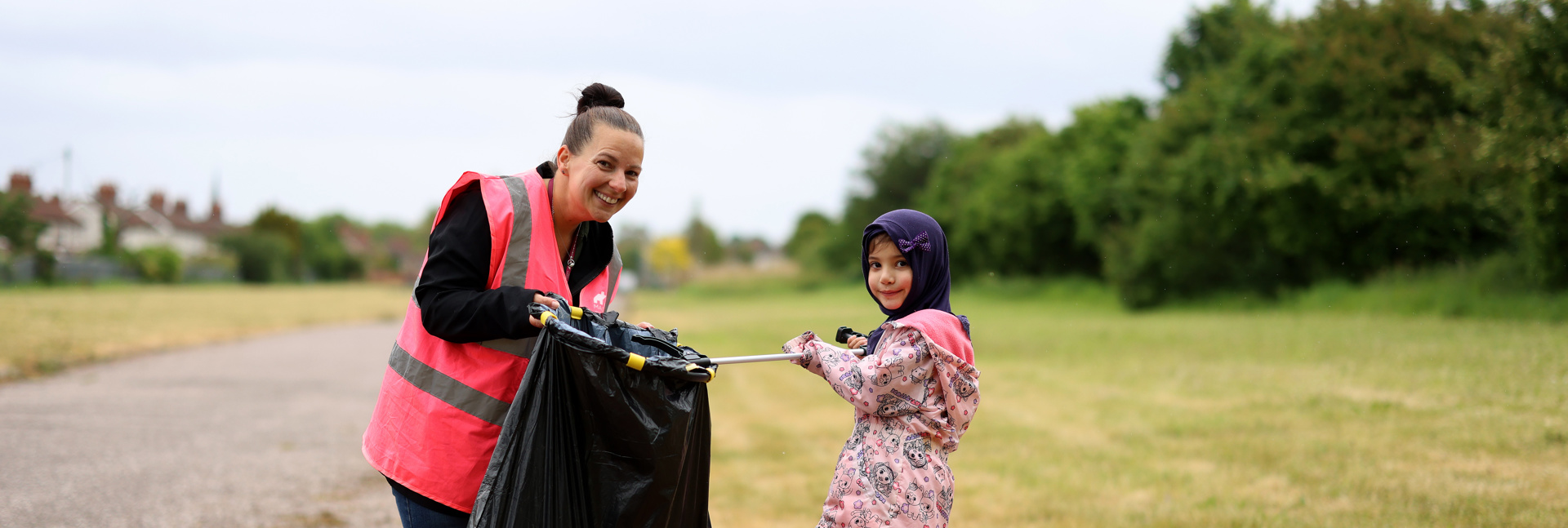 Customer and colleague taking part in a community litter pick, collecting rubbish. 