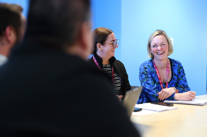 Female staff member smiling with colleagues