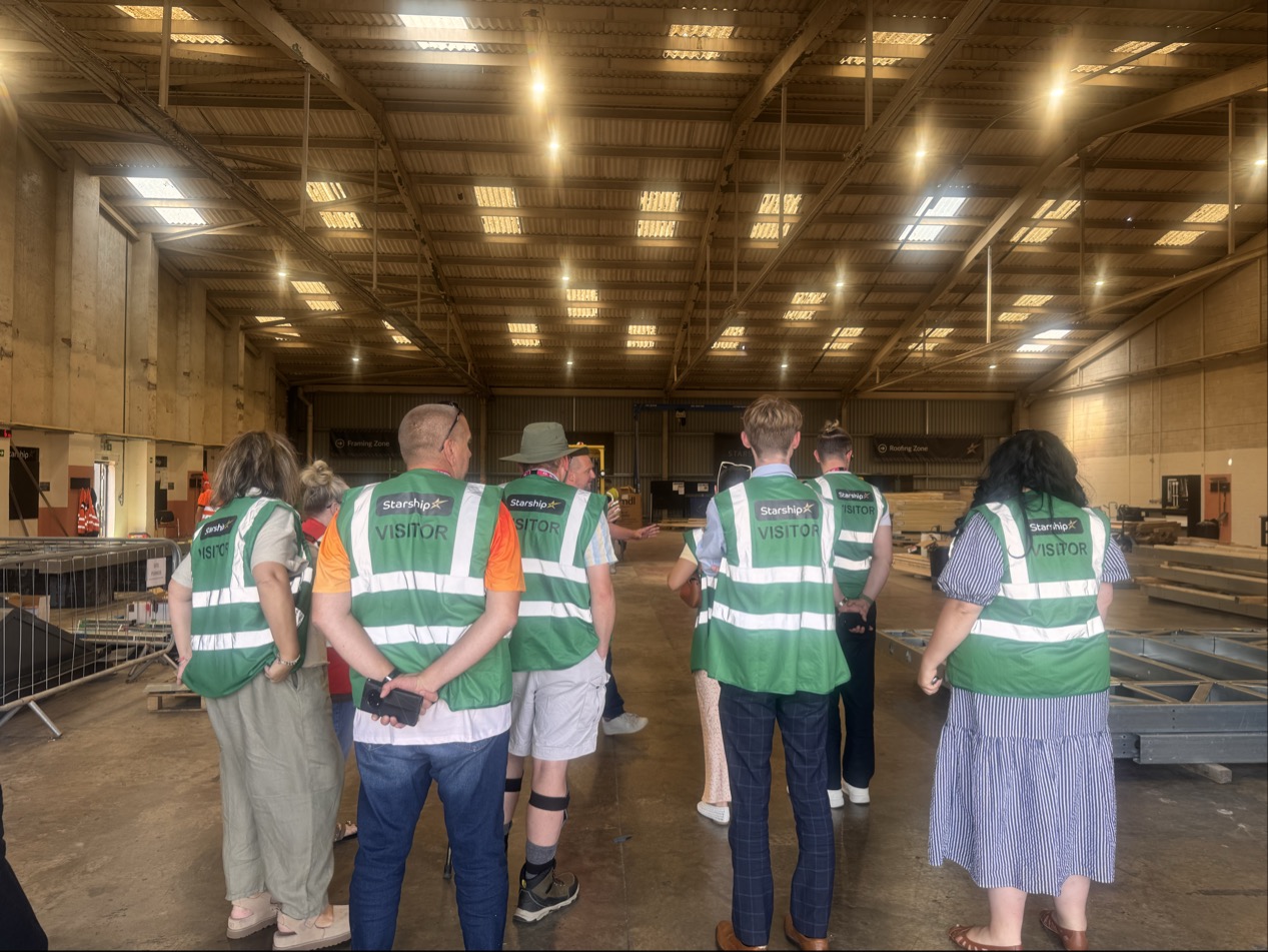 Members of the Magenta Customer and Communities Committee and Magenta colleagues wearing green visitor high-visibility vests tour Starship's manufacturing facility in Birkenhead. 