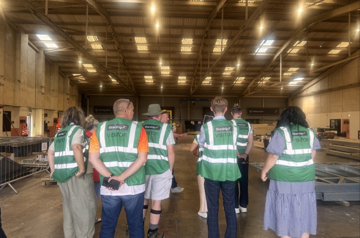Members of the Magenta Customer and Communities Committee and Magenta colleagues wearing green visitor high-visibility vests tour Starship's manufacturing facility in Birkenhead. 