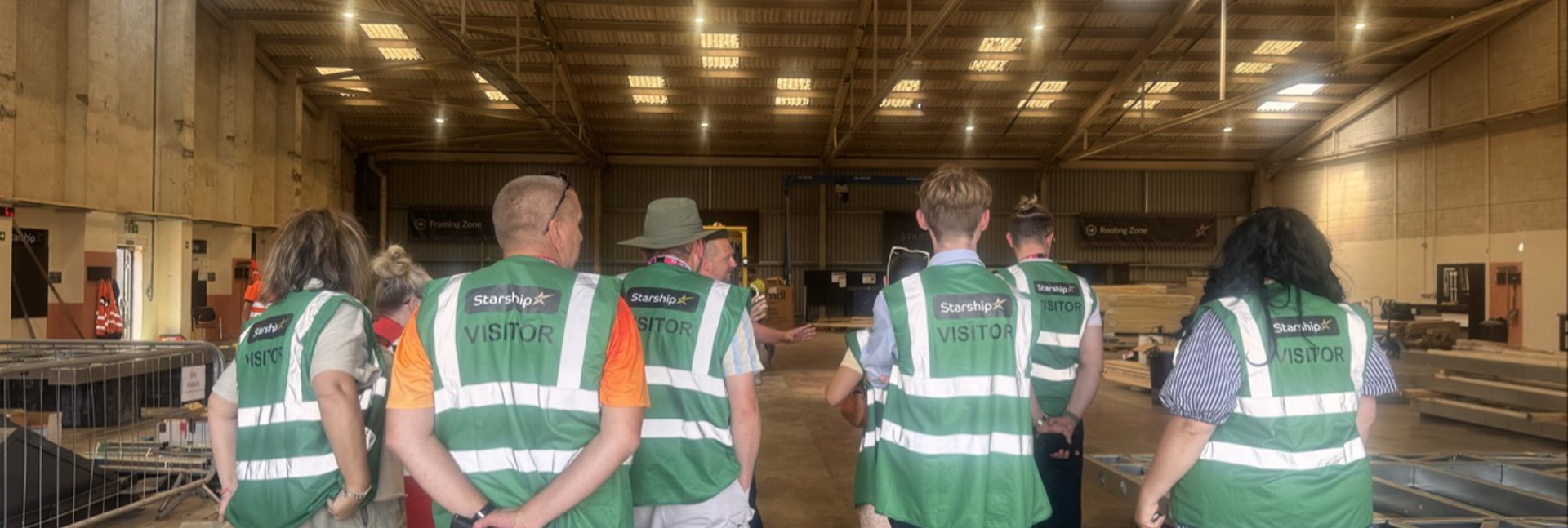 Members of the Magenta Customer and Communities Committee and Magenta colleagues wearing green visitor high-visibility vests tour Starship's manufacturing facility in Birkenhead. 