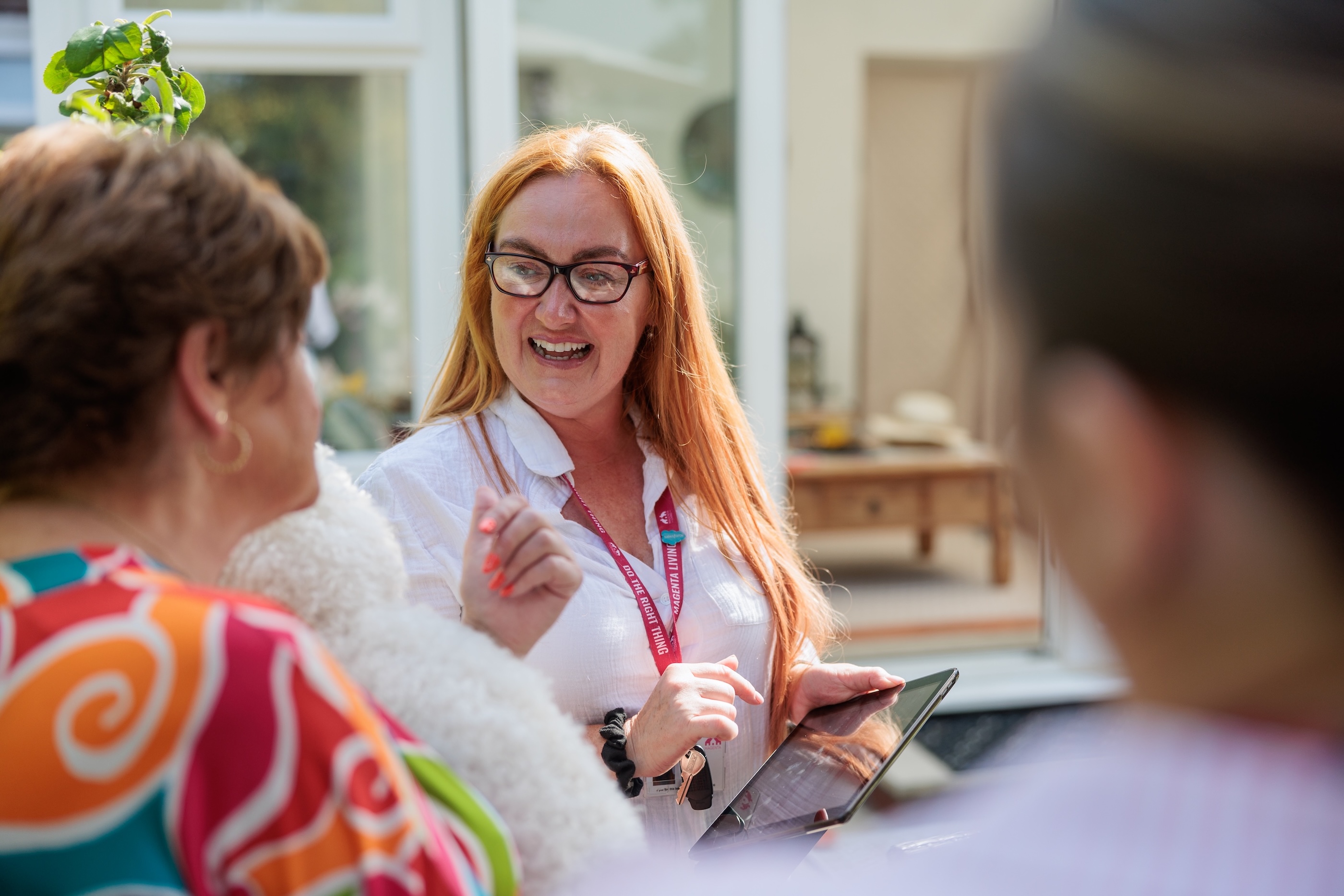 Magenta Living colleague speaking with customers in an outdoor communal area.