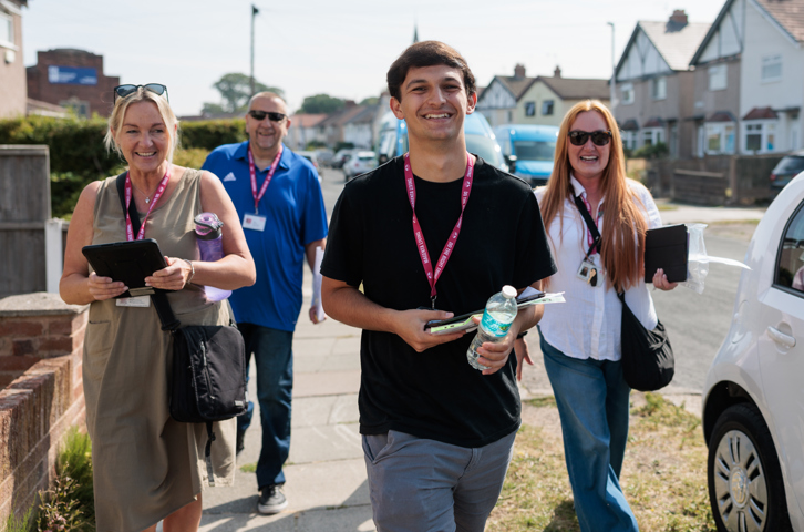 Four Magenta Living colleagues smiling when out in the community for the Big Door Knock event